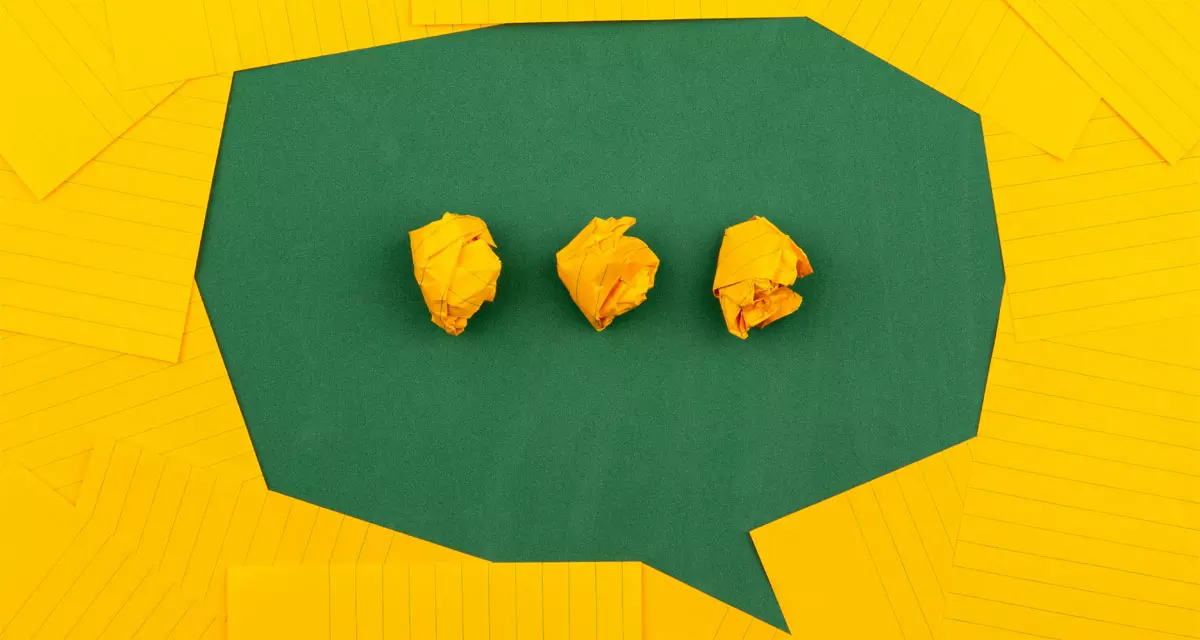 3 zerknüllte gelbe Papiere auf grüner Oberfläche, umgeben von gelb linierten Papieren. Foto: unsplash.com | Volodymyr Hryshchenko 
